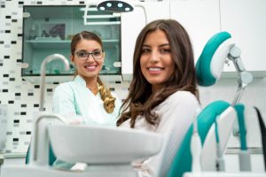 woman smiling in dentist chair with her dentist next to her